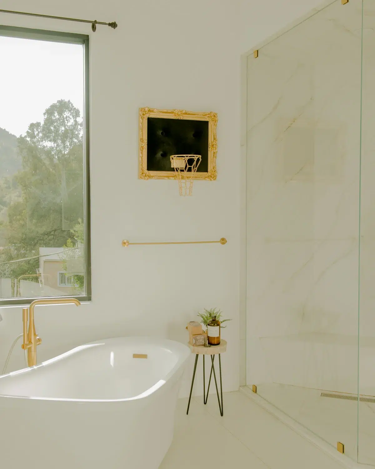 A white and gold bathroom with a stunning Black Velvet Hoop bathtub.