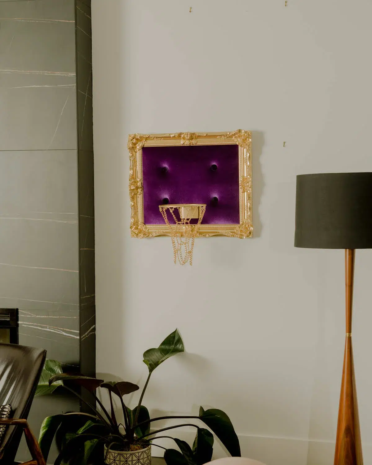 A regal hoop decorates the wall of a living room, adorned in luxurious purple velvet.