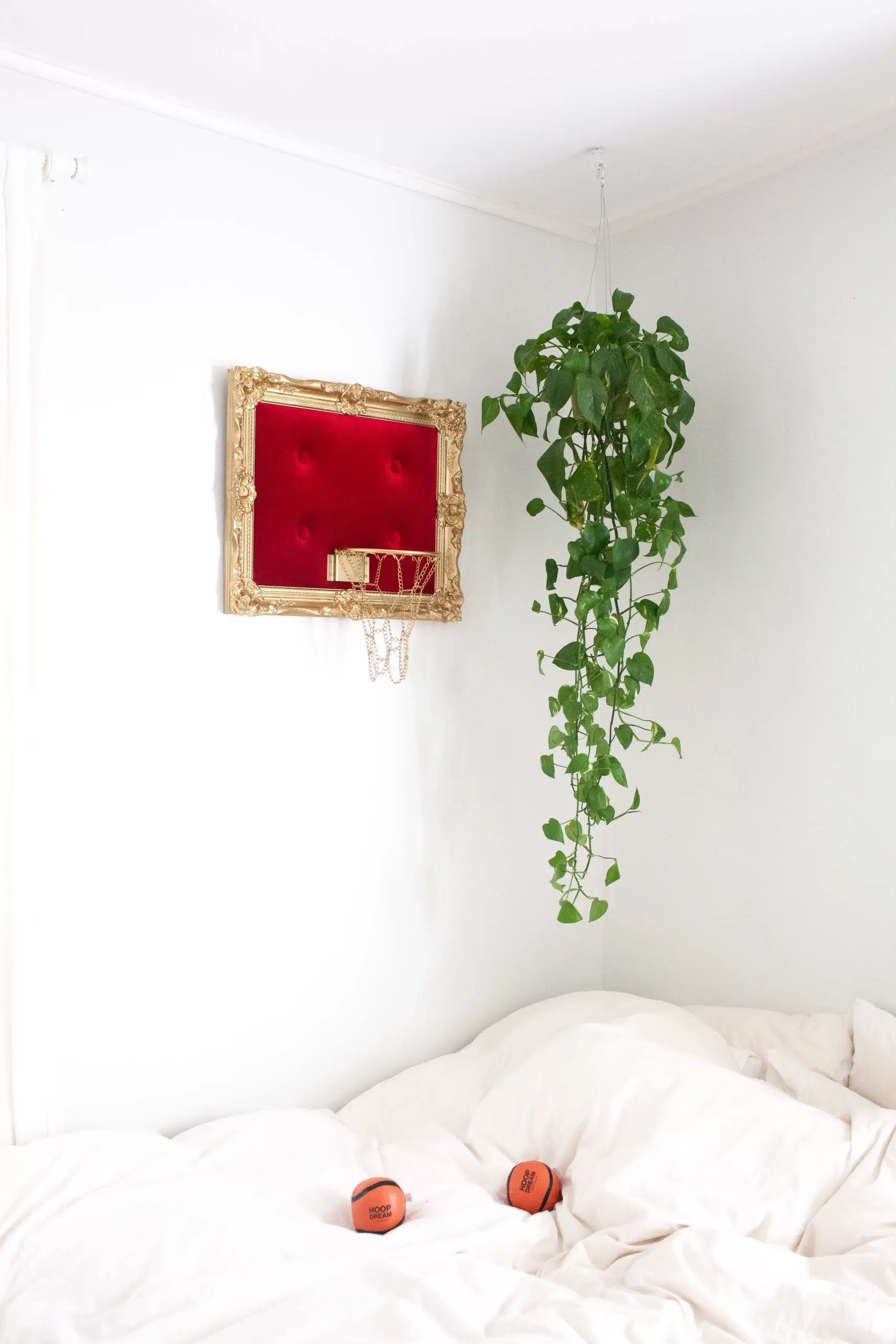 A white bed adorned with a luxurious Red Velvet Hoop.