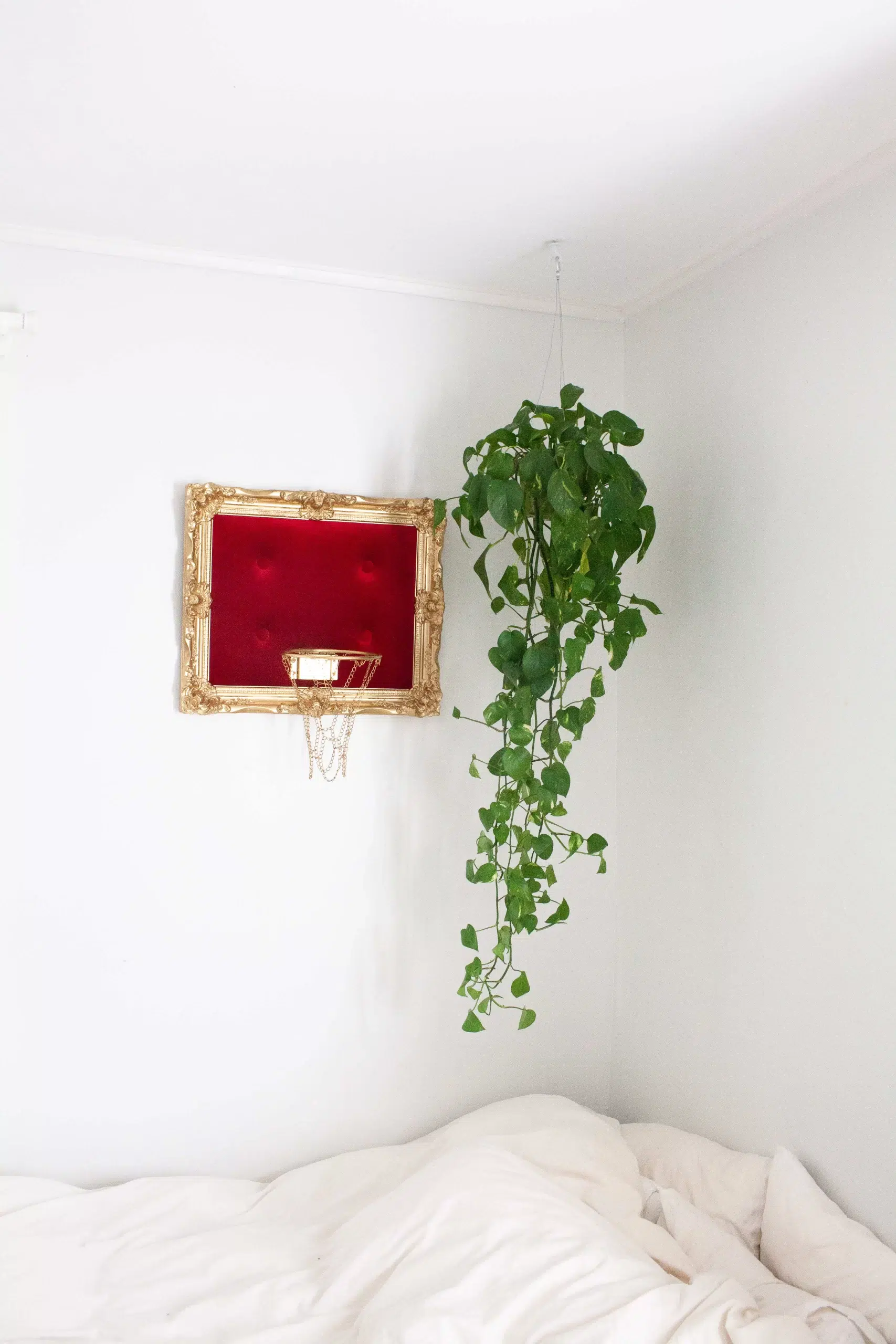 A bed with a hanging Red Velvet Hoop above it.