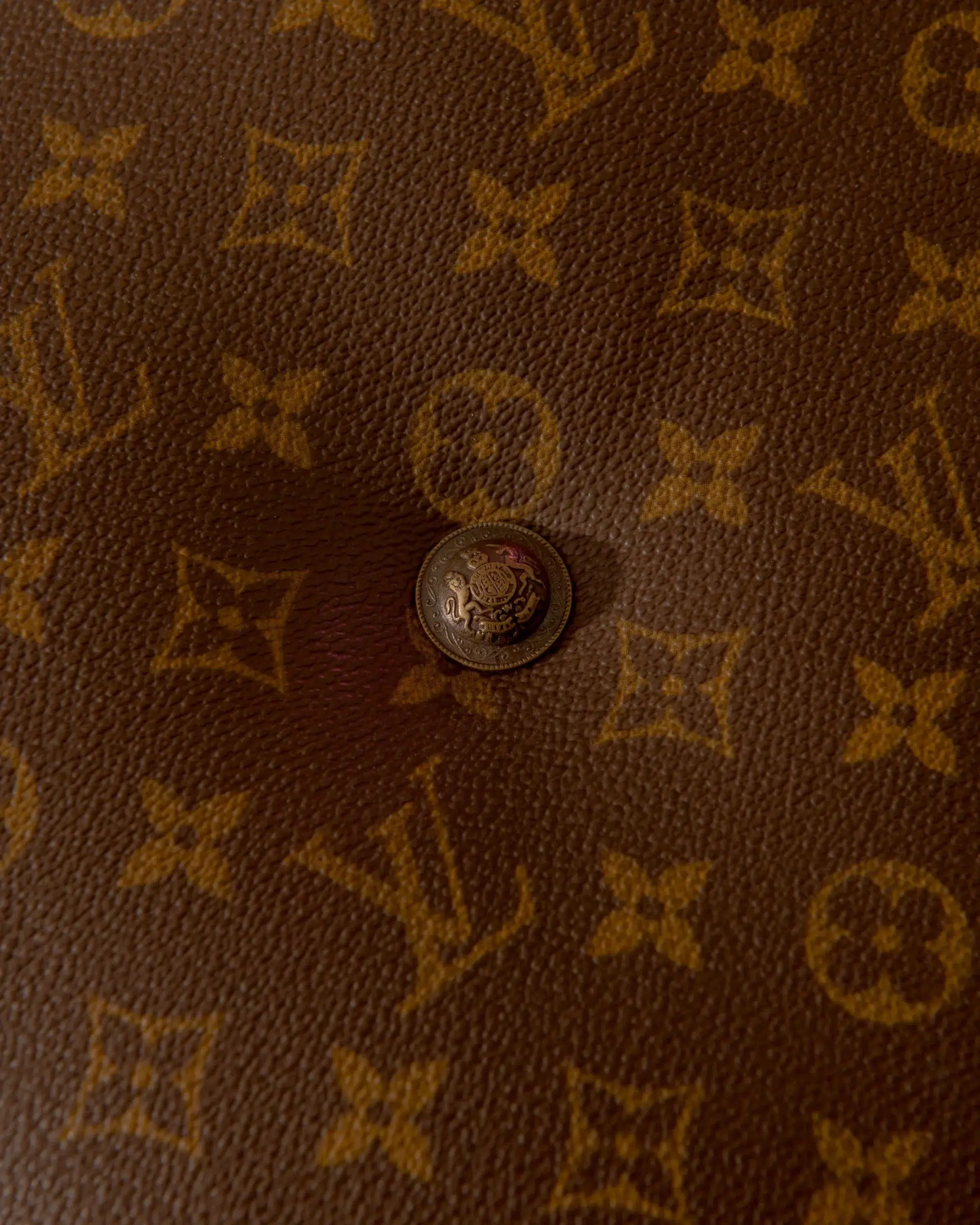 A Hoop bag by Louis Vuitton featuring a button closure.