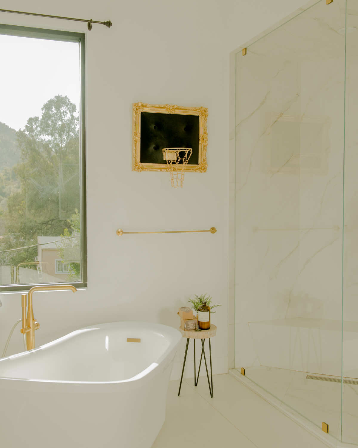 A white and gold bathroom with a bathtub.