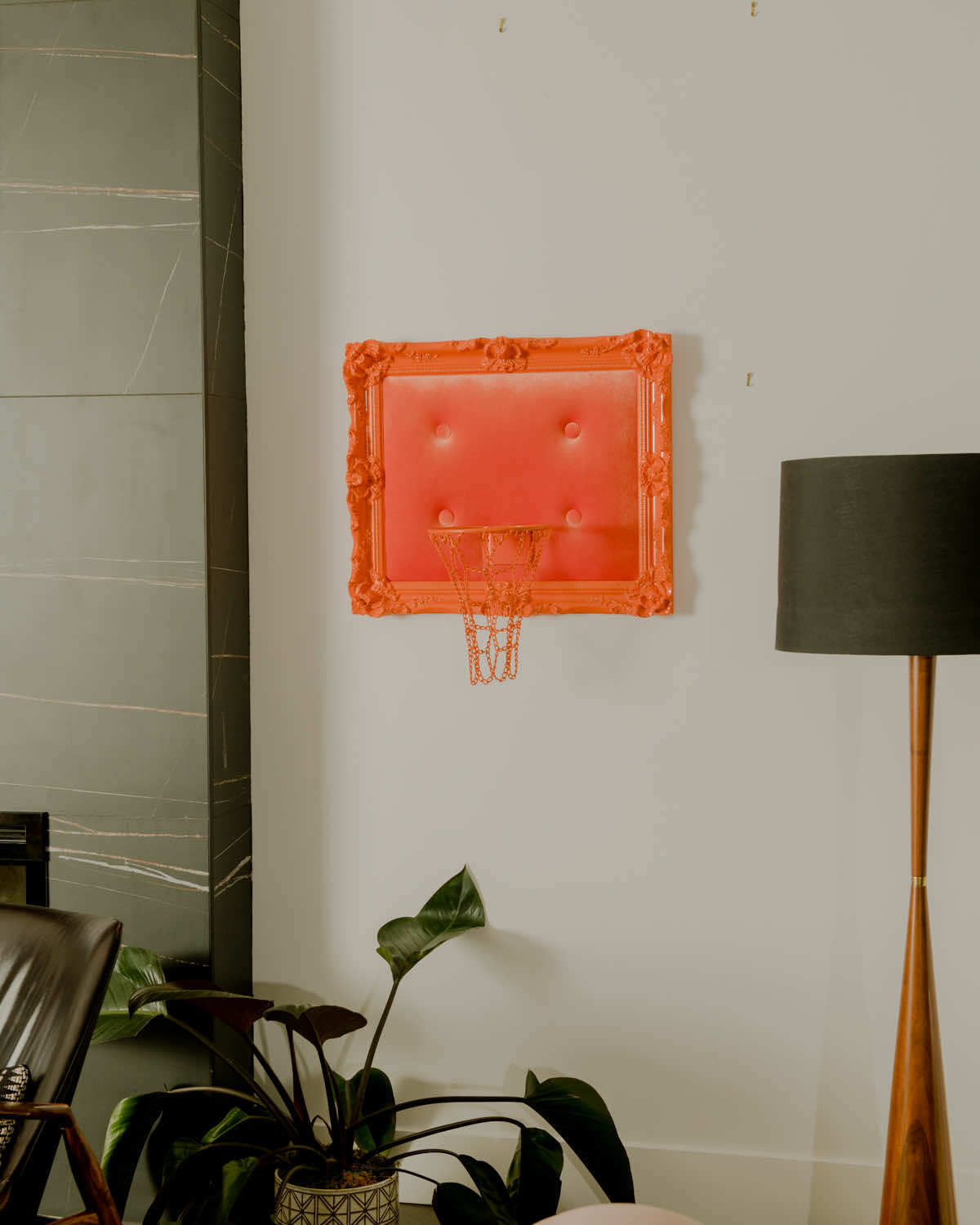 A living room with a basketball hoop on the wall.