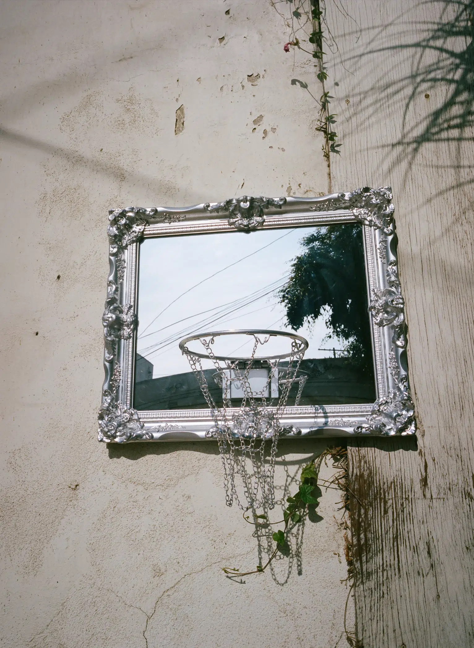 A basketball hoop is reflected in a mirror on a wall.