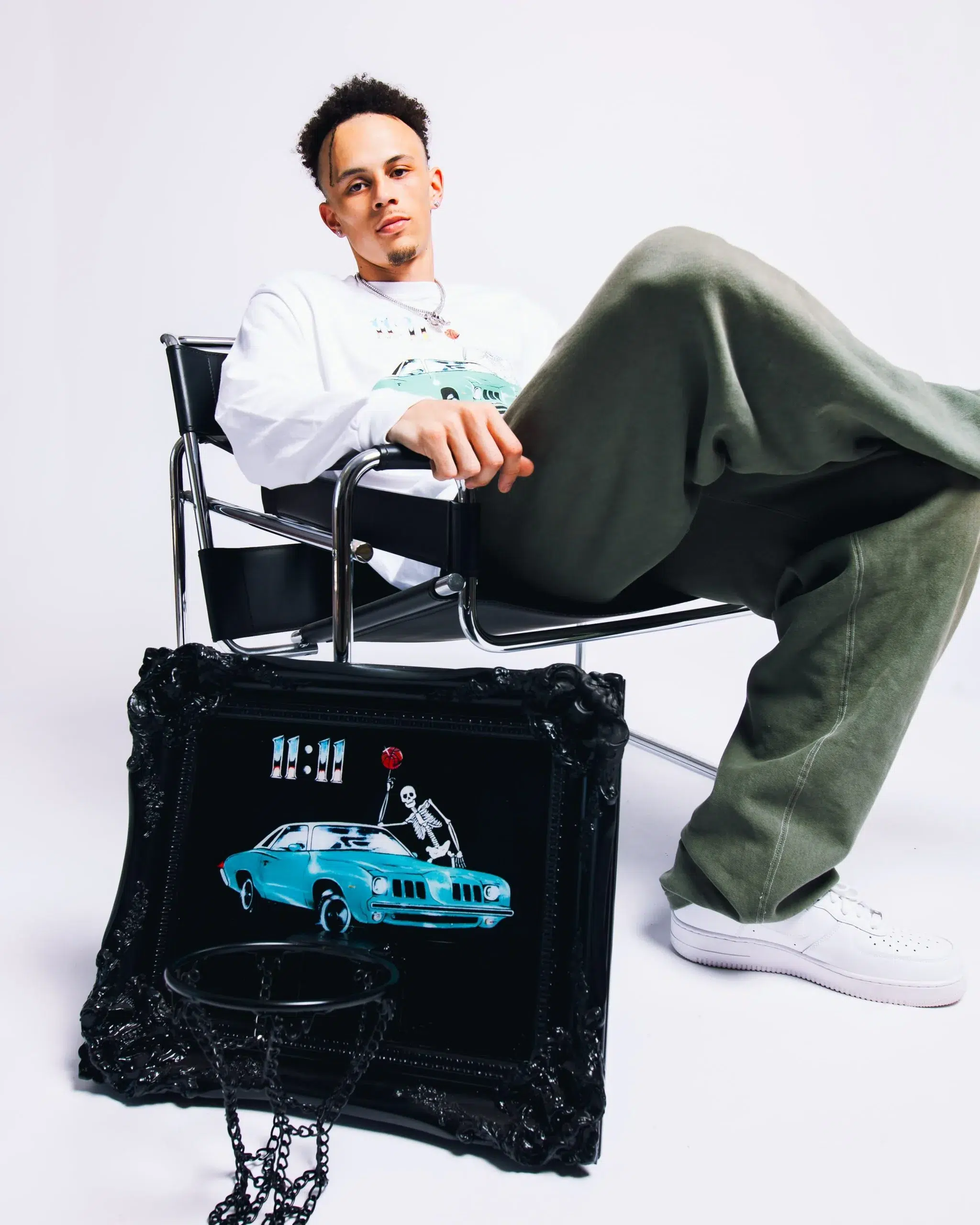 A man sitting on a chair with a picture of a car.