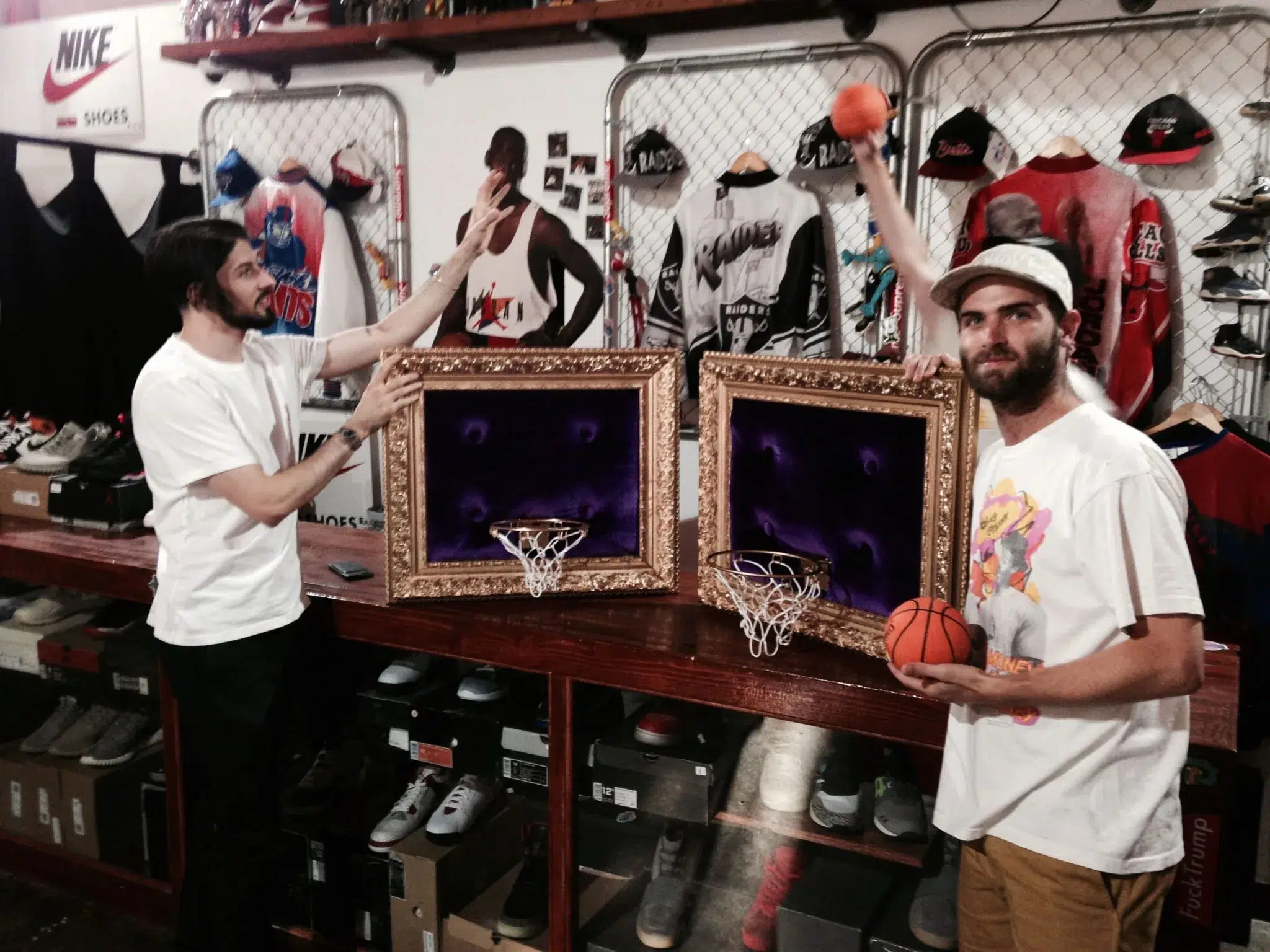 Two men standing next to a basketball hoop in a store.