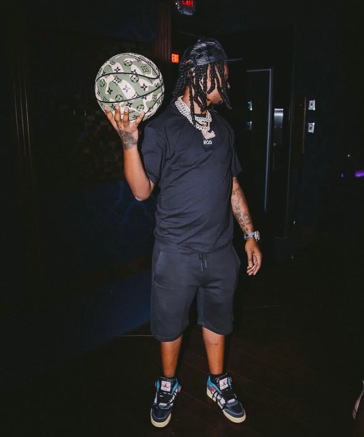 Lil wayne holding a basketball in his hands.