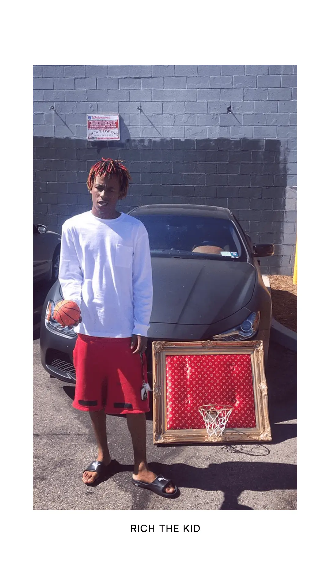 A man standing next to a car with a basketball hoop.
