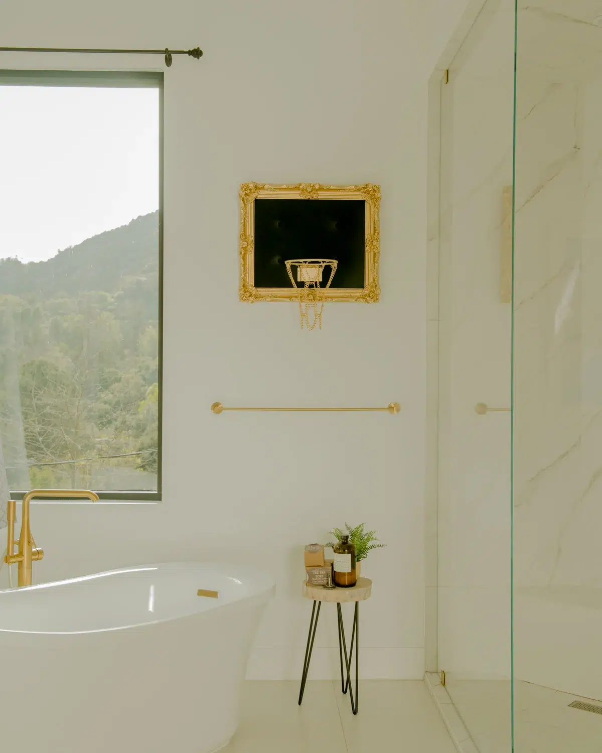 A luxurious home bathroom with a gold tub and mirror.