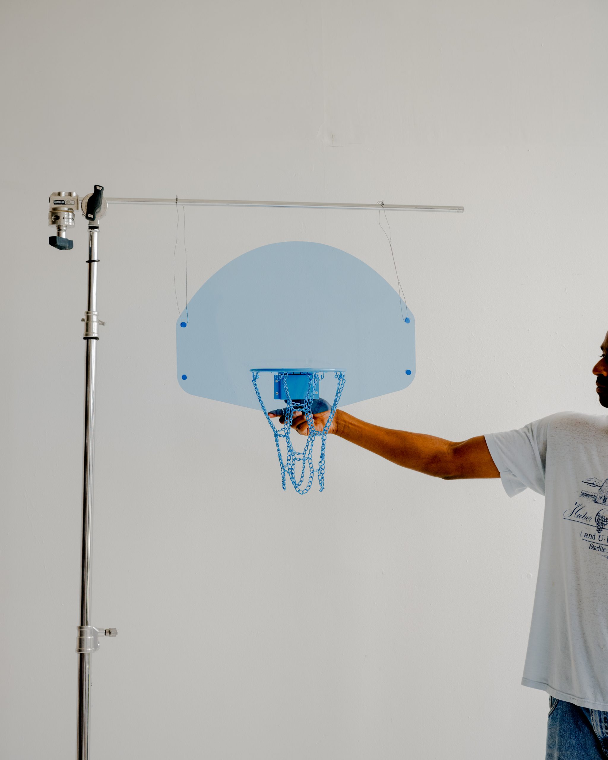 Person in a white T-shirt holds an Acrylic Hoop - Blue, attached to a metal stand, against a plain white background.